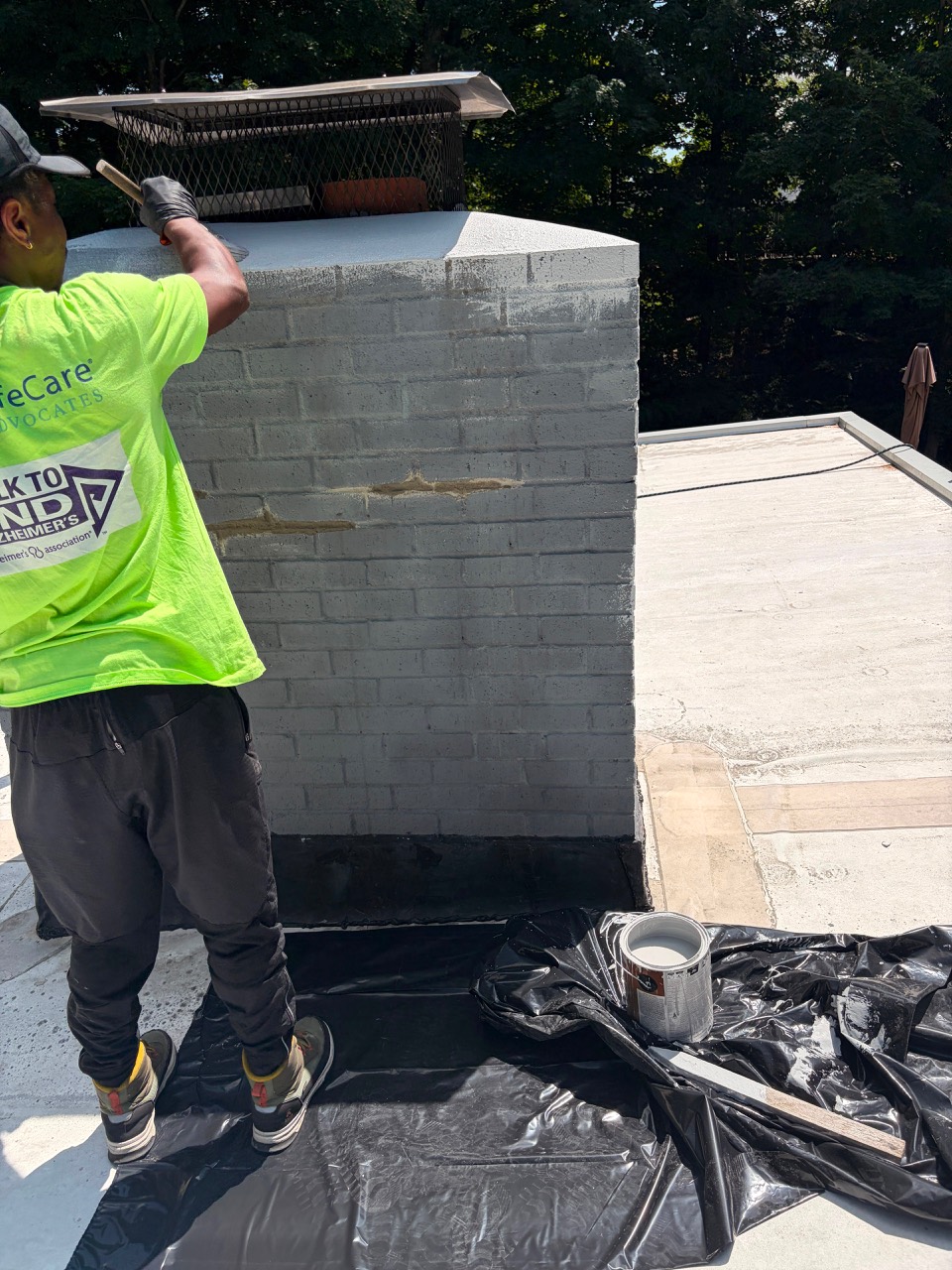 Technician painting a repointed chimney in Wayland MA