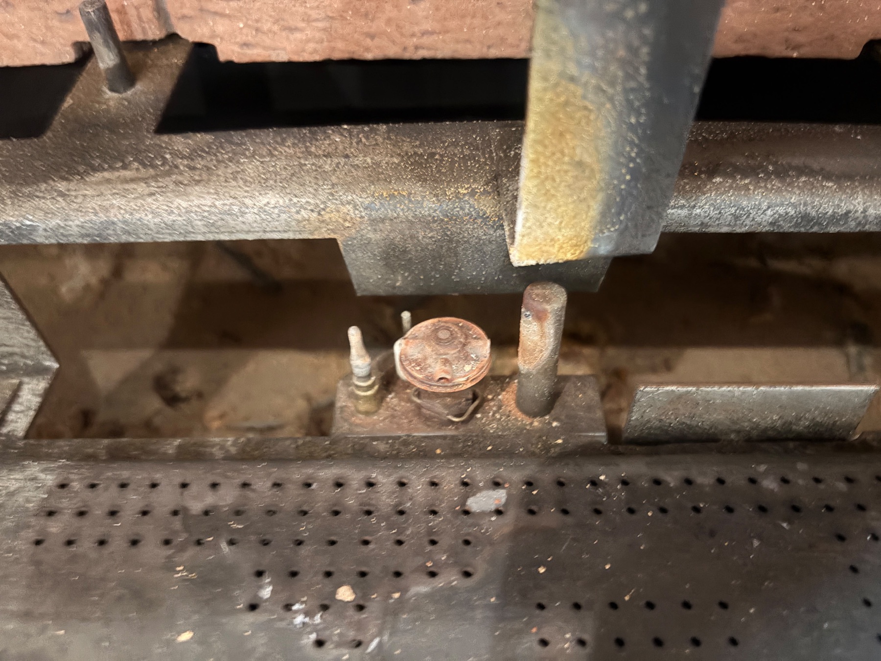 Old gas fireplace pilot assembly before replacement in Londonderry NH